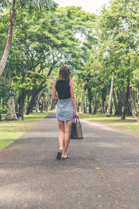 Rear view of woman walking on road