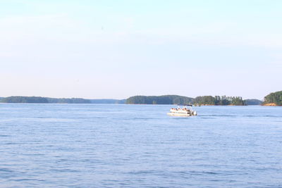 Boat sailing in calm blue sea against sky