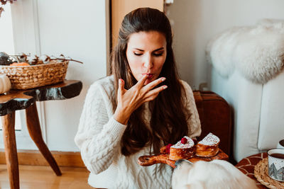 Young woman sitting on sofa at home