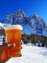 Person holding ice cream cone against mountain