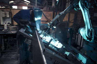 Welder welding metal with robot