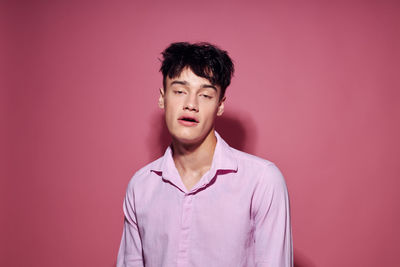 Portrait of young man against green background