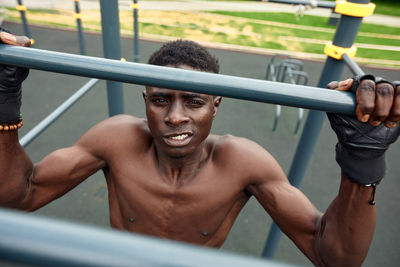 Low angle view of young man exercising on railing