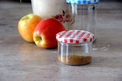 Close-up of apples in glass jar on table