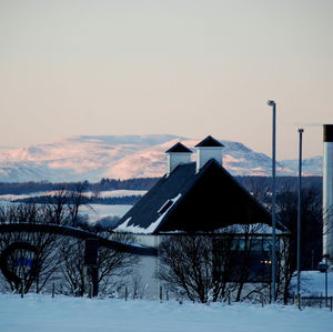 Barn on field against clear sky during winter