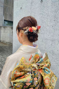 Rear view of woman standing against wall