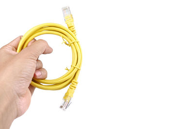 Close-up of hand holding ring over white background