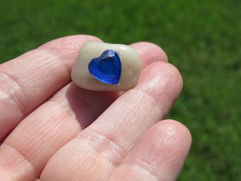 Close-up of hand holding blue ring