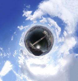 Directly below shot of glass ball against blue sky