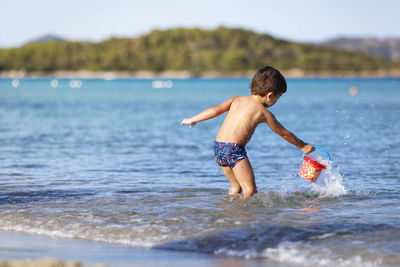 Rear view of woman swimming in sea