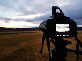 Low angle view of camera on field against sky