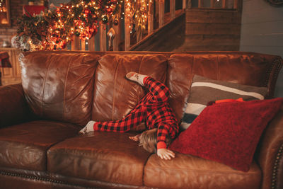 Portrait of woman sitting on sofa at home