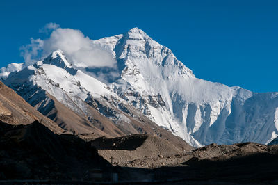 Scenic view of snowcapped mountains against blue sky