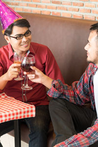 Smiling friends toasting drinks during christmas party