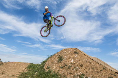 Low angle view of man jumping while doing bmx cycling