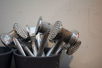 Close-up of utensil table against wall