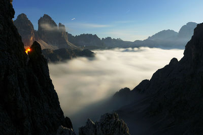 Scenic view of cloudscape amidst rocky mountains against sky