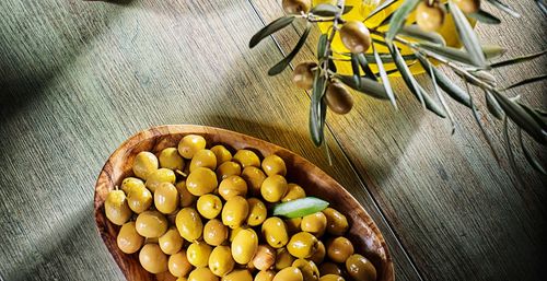 High angle view of green olives in bowl on table