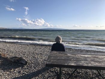 Rear view of man sitting on bench