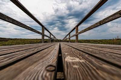 Surface level of boardwalk against sky