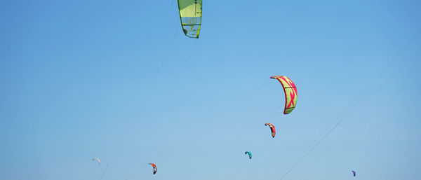 Low angle view of kite flying against clear blue sky