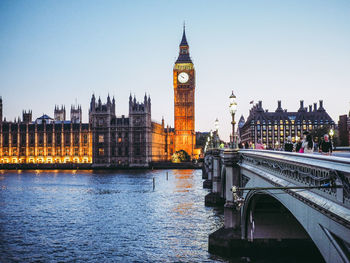 Tower bridge over river and buildings against clear sky