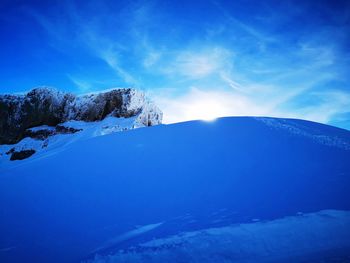 Scenic view of snowcapped mountains against blue sky