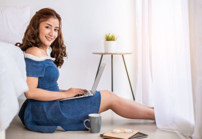 Young woman using mobile phone at home