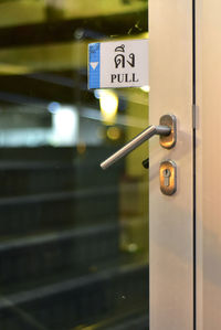 Close-up of information sign on metal door