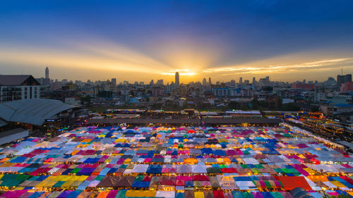 Colorful tents against sky in city during sunset