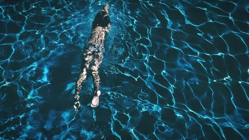 High angle view of girl swimming in swimming pool