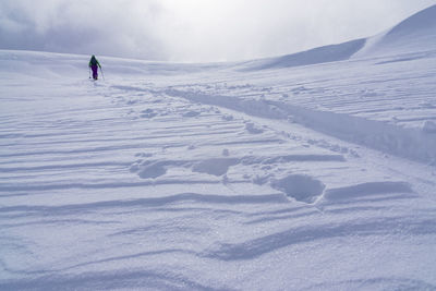 Footprints on snow covered landscape