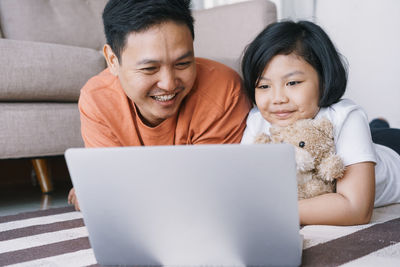 Portrait of a smiling young man using laptop