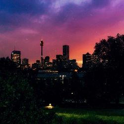 View of illuminated cityscape against cloudy sky