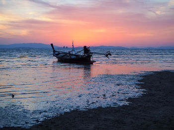 Silhouette boat in sea against sky during sunset