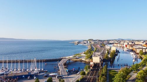 High angle view of sea and buildings against clear sky