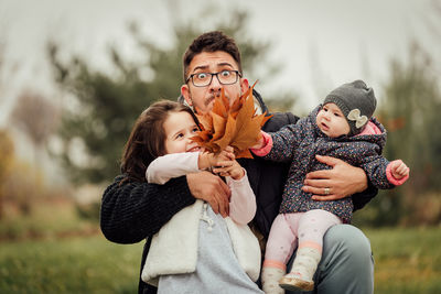 Portrait of father with daughters in park