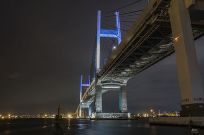 Low angle view of bridge over river at night