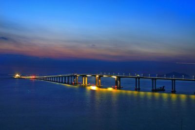 Bridge over calm sea against sky