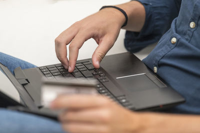 Midsection of man using laptop on table