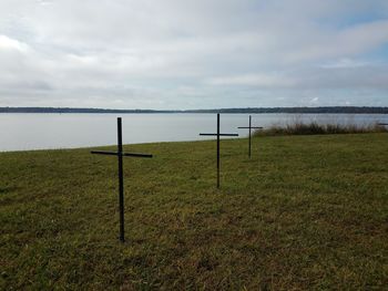 Wooden posts on field against sky