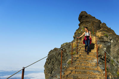 Low angle view of woman standing against clear sky