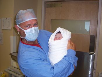 Portrait of doctor carrying newborn baby in hospital