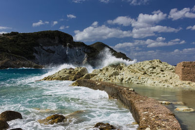 Rocks in sea against sky