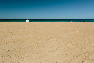 Tourists on beach against sky