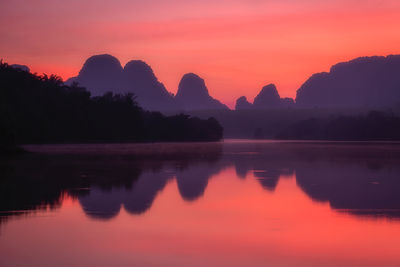 Scenic view of lake against romantic sky at sunset