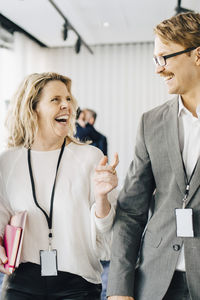 Happy female walking with coworkers in office