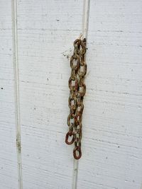 Close-up of chain hanging against wall