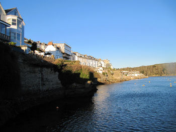 Buildings in city against clear blue sky