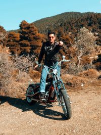 Portrait of man riding motorcycle on field